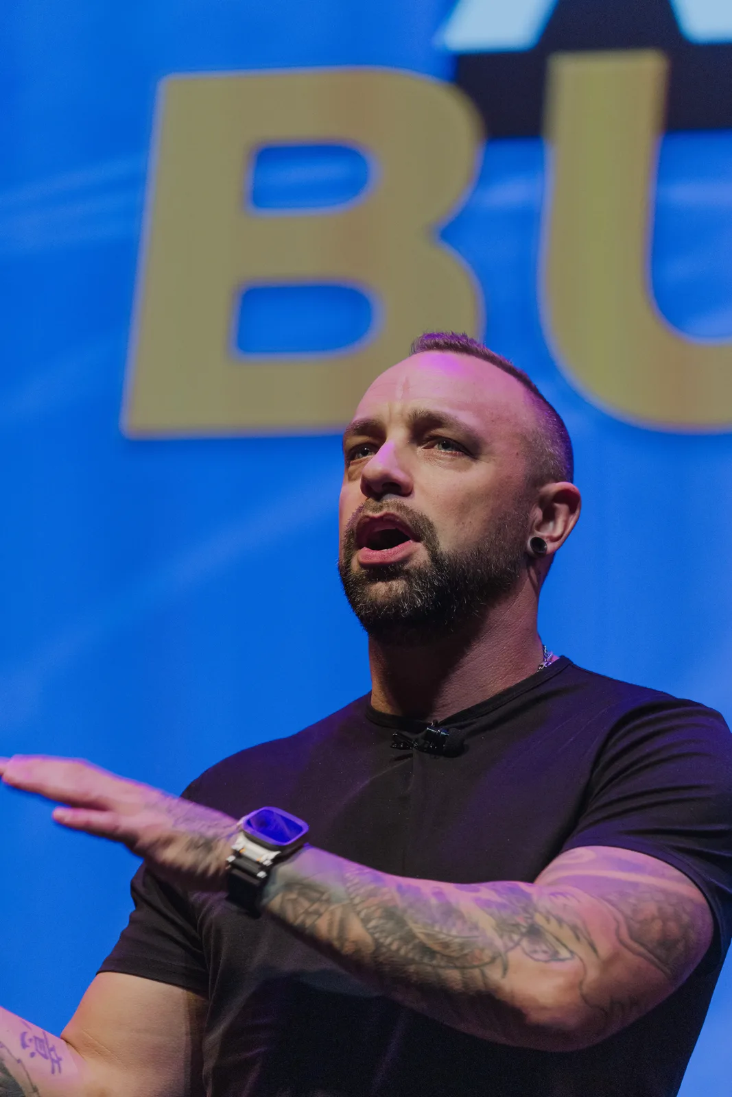 Aaron Pierson delivering an AI keynote on a blue-lit stage