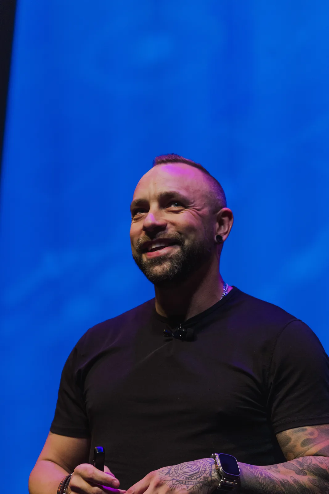 Aaron Pierson smiling on stage under blue lights